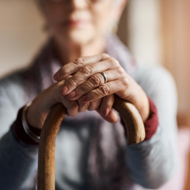 1091764324 Cropped shot of a senior woman holding a cane in a retirement home
